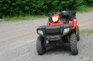 ATV (All Terrain Vehicle) on path in the midst of a forest.