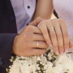 Husband and wife holding hands on wedding day.